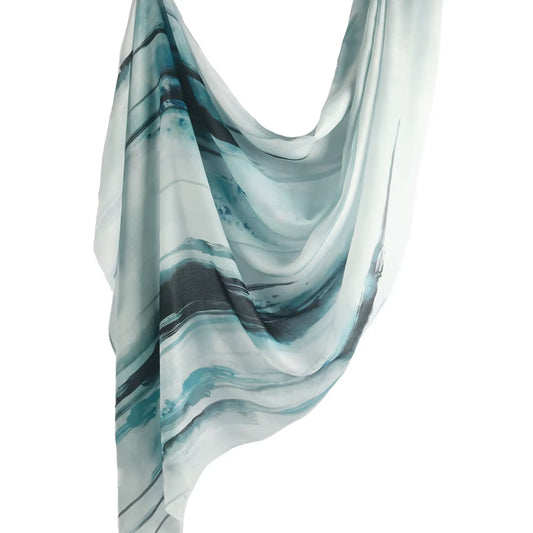 Cotton-modal hijab named Tidemist featuring abstract oceanic marbling in teal, grey, and black — evoking misty coastal waves and serene sea textures.

